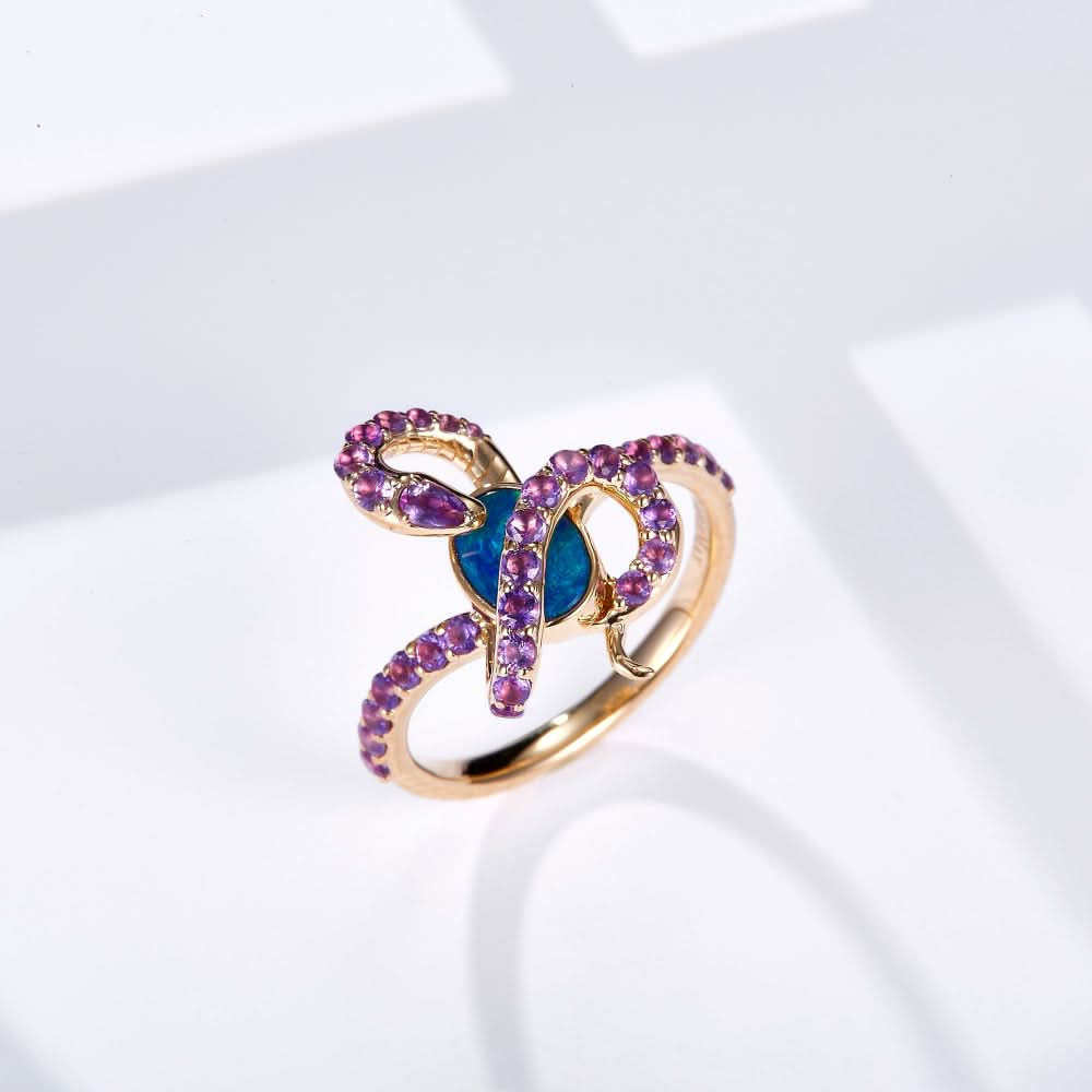 18K gold ring featuring an oval Australian opal with a snake design set in yellow gold, adorned with natural amethyst gemstones for a vibrant contrast.